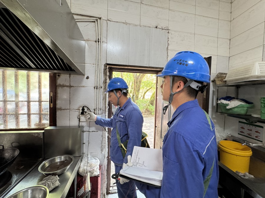 图四为：旧院供电所工作人员检查景区餐饮店线路开关